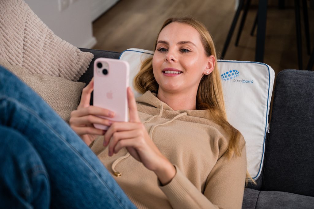 Femeie folosind telefonul si Perna Omnipemf Cotton